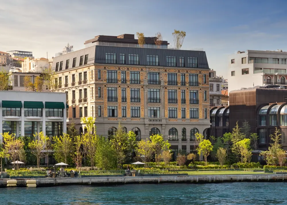 An image displaying the elegant interior of a luxury hotel in Istanbul, Turkey. The lobby features sophisticated decor, comfortable seating areas, and a grand chandelier, evoking a sense of opulence and hospitality. The warm lighting and inviting ambiance create a welcoming atmosphere for guests exploring accommodation options in Istanbul.